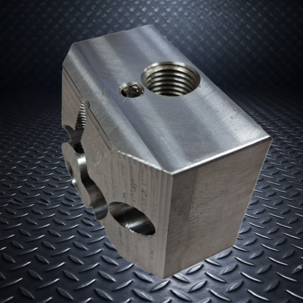 Precision CNC machined aluminum block with threaded bore and multi-axis milling features.